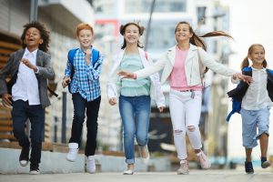 School children running together outdoors