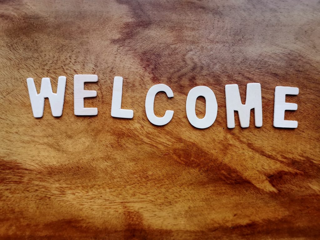White Welcome Text on Wooden Table Background